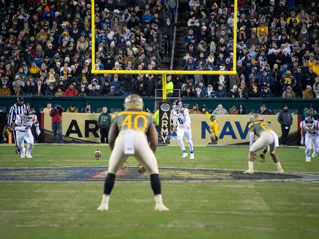 The image shows a football game being played in a stadium, with people wearing sports dress and...