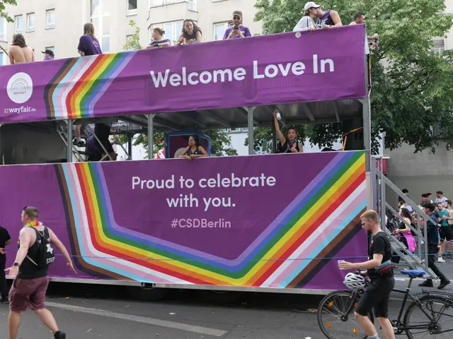 The image shows a group of people riding on top of a double decker bus in a parade. The bus is...