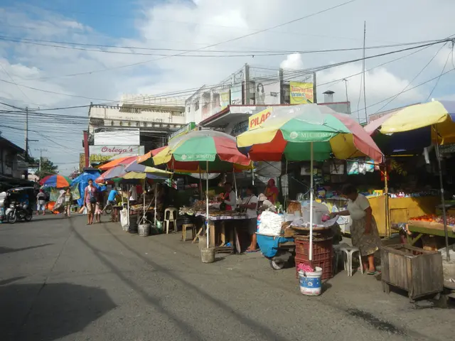 The image shows a bustling street market with a group of people walking down the street under...