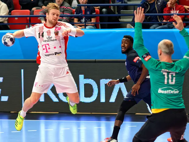 The image shows a group of men playing a game of handball on a court, with a ball in the center of...