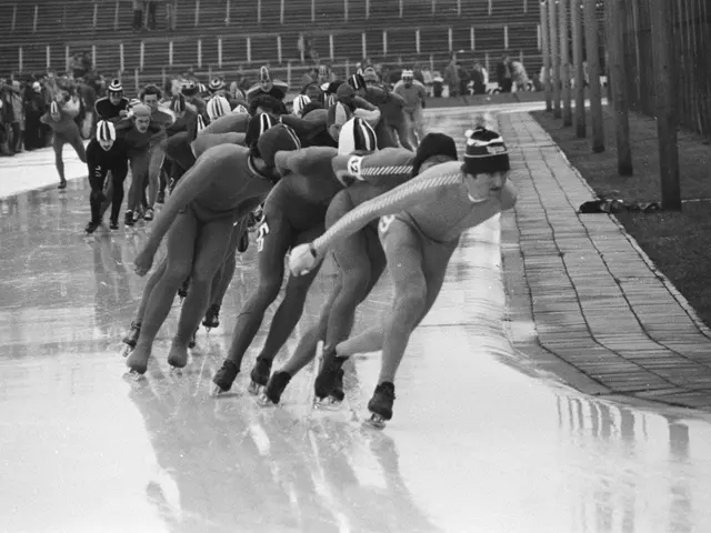 The image shows a group of speed skaters racing down a track, wearing helmets and skating shoes. On...