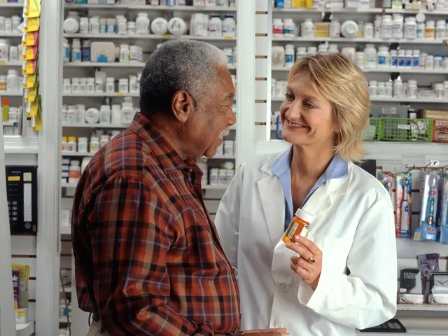 The image shows a pharmacist talking to a customer in a pharmacy. The pharmacist is wearing a white...