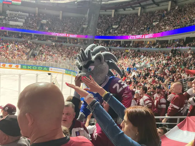 The image shows a group of people standing in front of a crowd at a hockey game. In the center of...