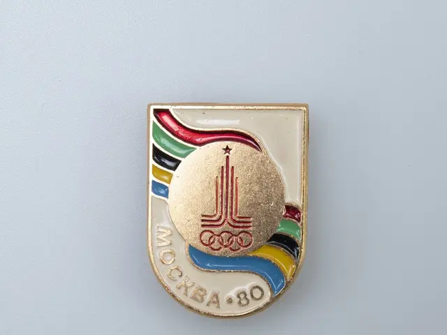 The image shows a white surface with a badge featuring the emblem of the 1980 Winter Olympics in...