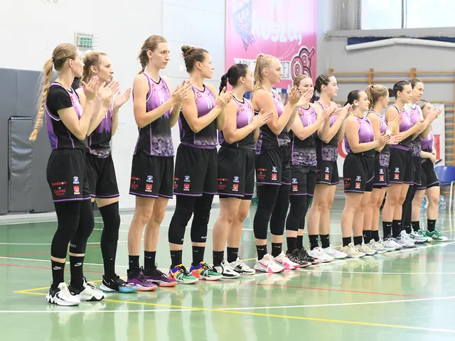 The image shows a group of women standing on top of a basketball court, clapping their hands in...