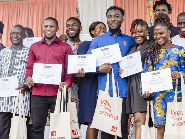 The image shows a group of people standing next to each other, smiling and holding certificates in...