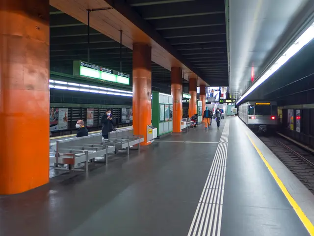 The image shows a train station with people waiting for the train on the railway track. There are...