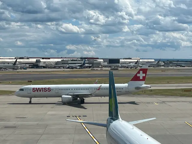 The image shows a Swiss Airlines Airbus A320-200 on the runway at Zurich Airport, surrounded by...