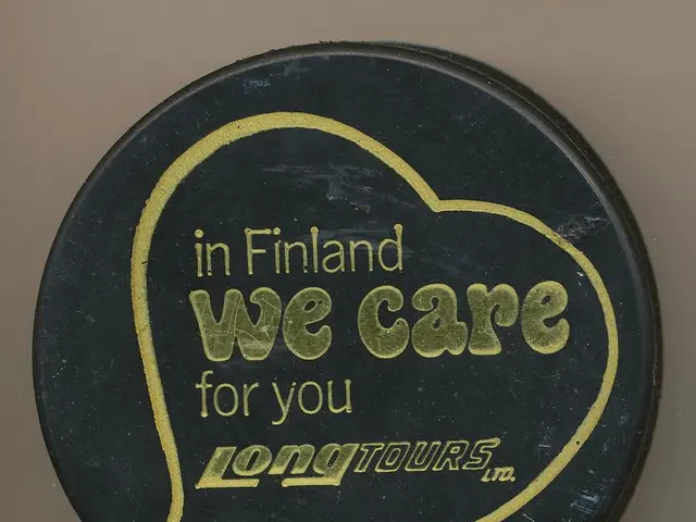 The image shows a black hockey puck with the words "In Finland We Care For You Long Tours" written...