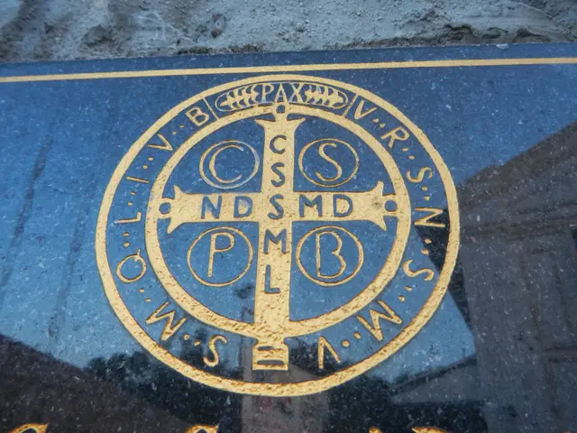The image shows a close up of a blue plaque with a gold cross on it, which is the logo of the...