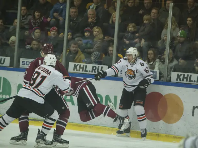 The image shows a group of people playing a game of ice hockey, wearing sports dress, helmets, and...