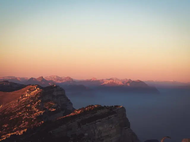 The image shows a breathtaking view of the Swiss Alps at sunset from the top of a mountain. The sky...