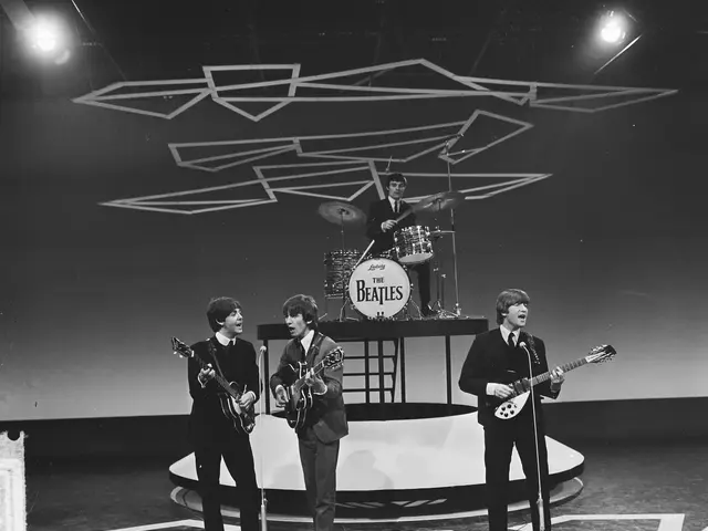 The image shows the Beatles on stage at the BBC Studios in London, England. The four members of the...