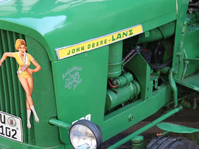 The image shows a green John Deere tractor with a sticker of a woman on the front, a number plate,...