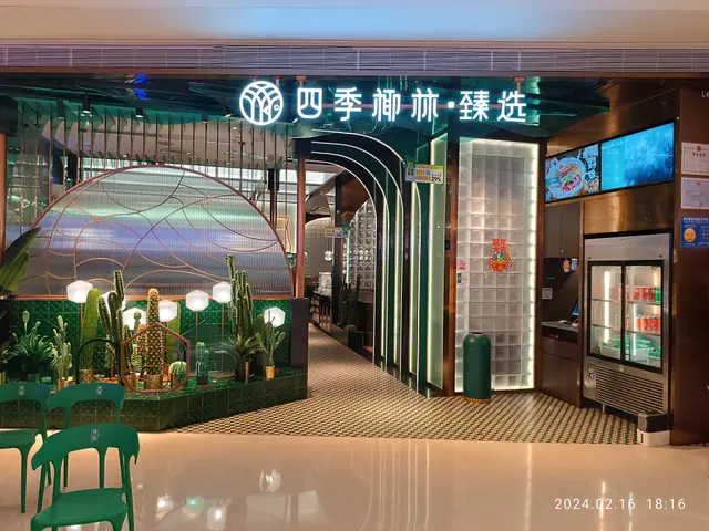The image shows the entrance to a Chinese restaurant with green chairs and tables, surrounded by...