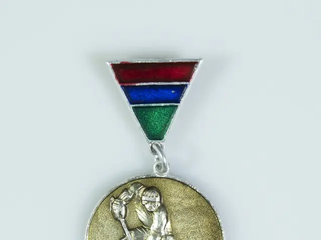 The image shows a gold medal with a hockey player on it, set against a white background. The medal...