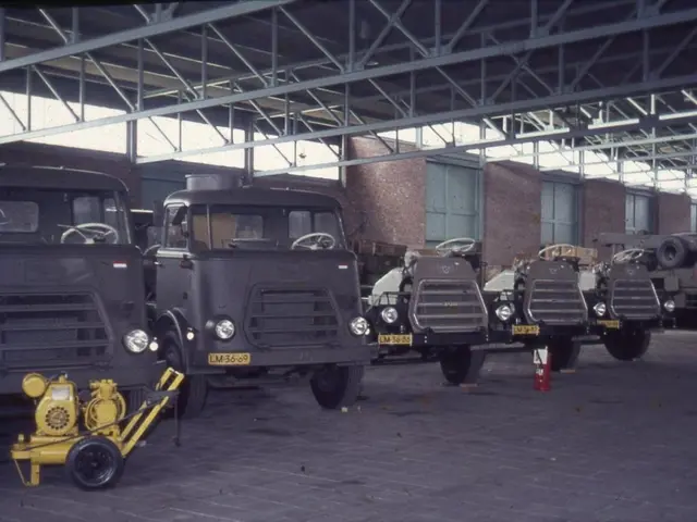 The image shows a group of trucks parked inside of a building, with a fire extinguisher on the...