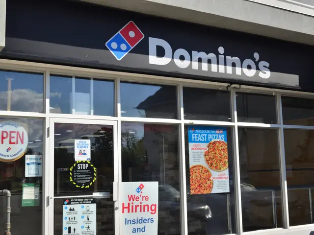 The image shows a Domino's Pizza restaurant with glass walls and doors, posters with text and...