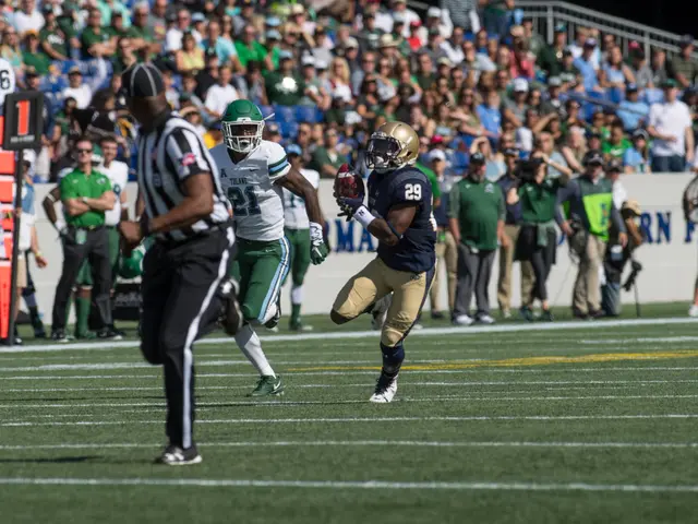 The image shows a football player running with the ball on a field, surrounded by a crowd of people...