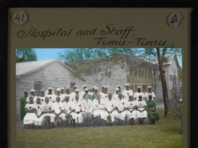 The image shows a group of nurses in white uniforms posing for a photo in front of a hospital in...