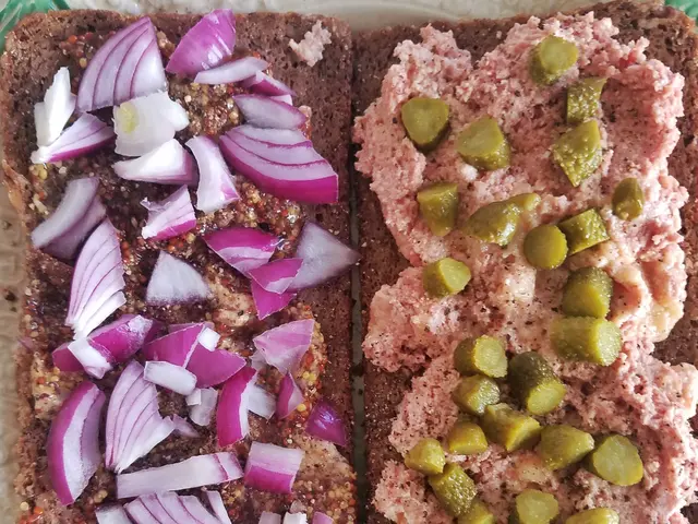 The image shows a plate with two slices of rye bread topped with red onion and pickles. The plate...