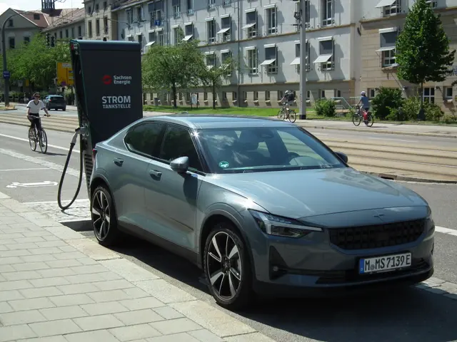 The image shows an electric car parked on the side of the road, with a charging station nearby....