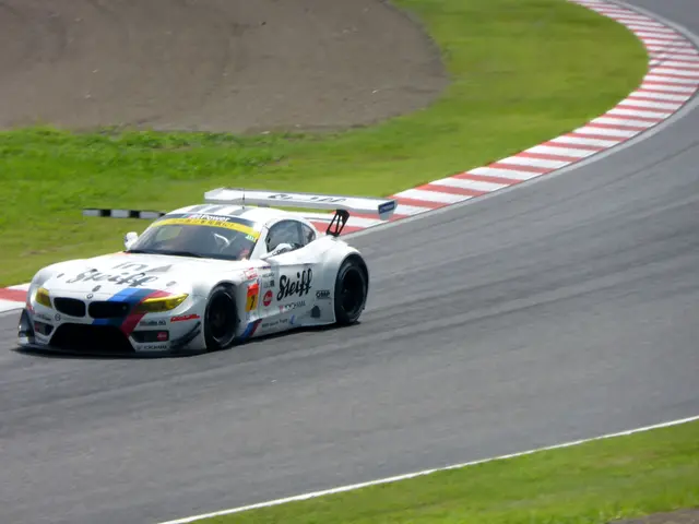 The image shows a BMW Z4 GT3 on the Nürburgring 24 Hours race track, surrounded by lush green...