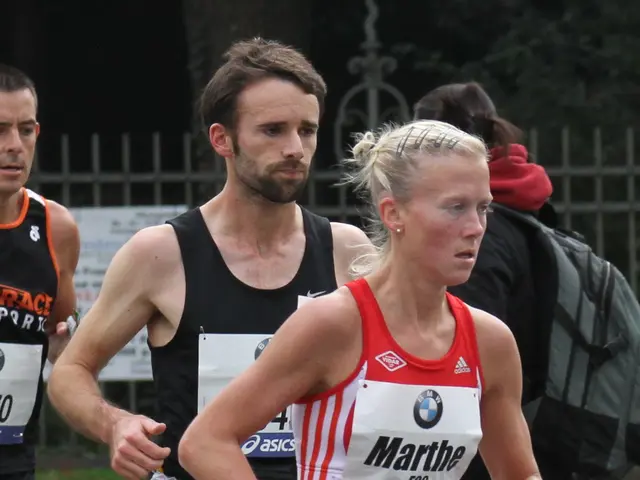 The image shows a group of people running in a marathon, with a woman in the lead wearing a sports...