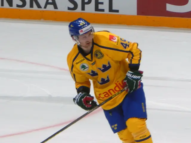 The image shows a hockey player in action on the ice, wearing a helmet, gloves, and footwear, and...