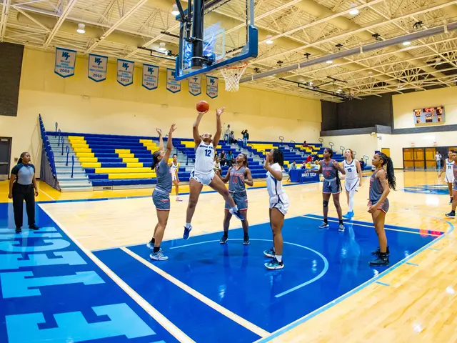 The image shows a group of women playing a game of basketball in a gymnasium with a basketball net...