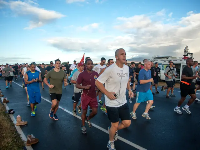 The image shows a group of people running in a marathon on a road surrounded by grass and footwear....
