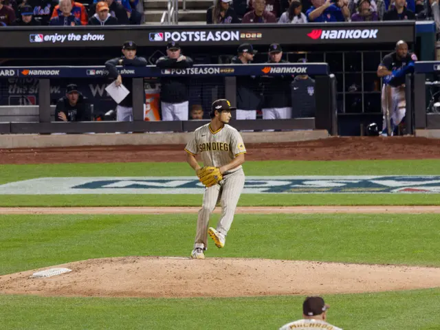 The image shows a baseball player pitching a ball on top of a field, surrounded by a group of...