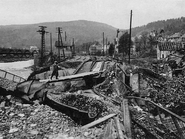 The image shows a black and white photo of a train track that has been destroyed by a landslide. We...