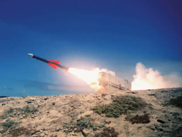 The image shows a missile being launched from a missile launcher in the desert, with fire and smoke...