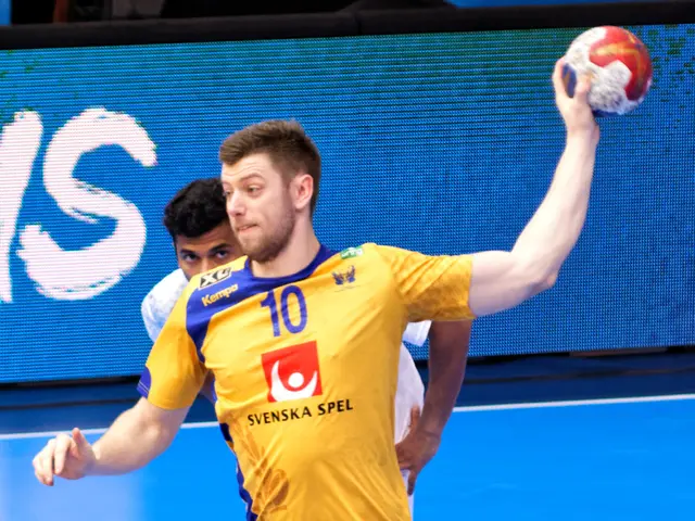 The image shows a man in a yellow shirt and blue shorts playing handball on a court, with a ball in...