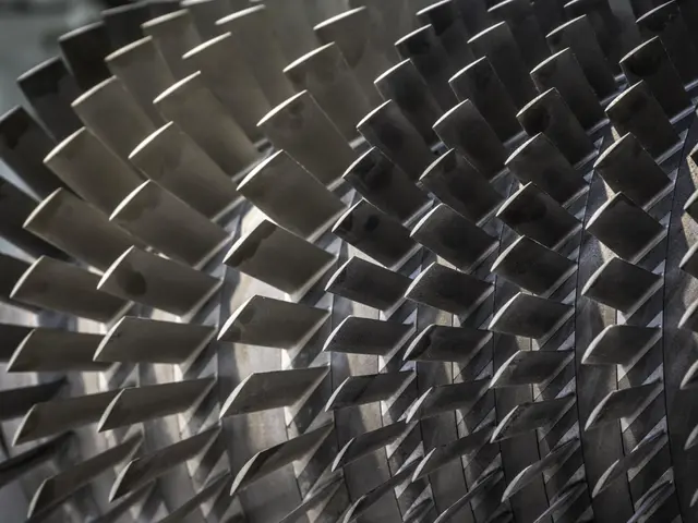 The image shows a close up of a jet engine with a lot of metal spikes on it, set against a blurred...