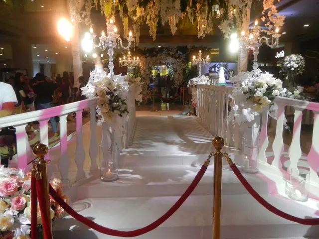 The image shows a wedding ceremony taking place in a mall, with a white carpeted floor, railings,...