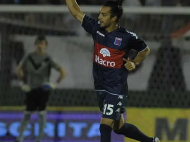 The image shows a soccer player celebrating after scoring a goal in front of a cheering crowd. The...