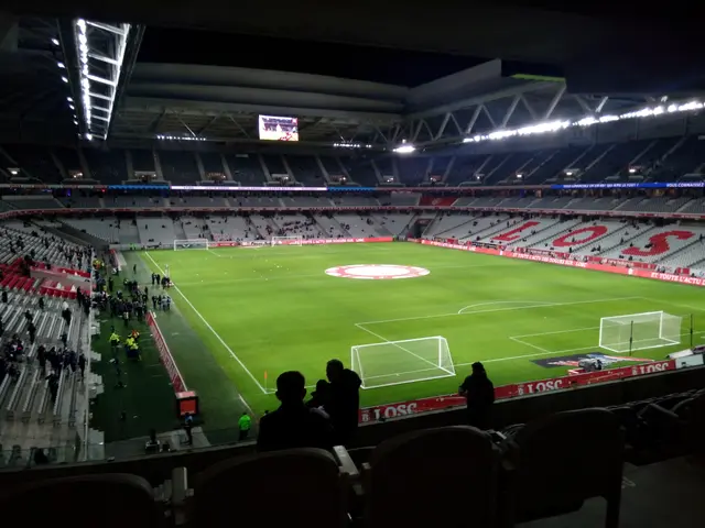 The image shows a large stadium filled with lots of people watching a soccer game. The stadium is...