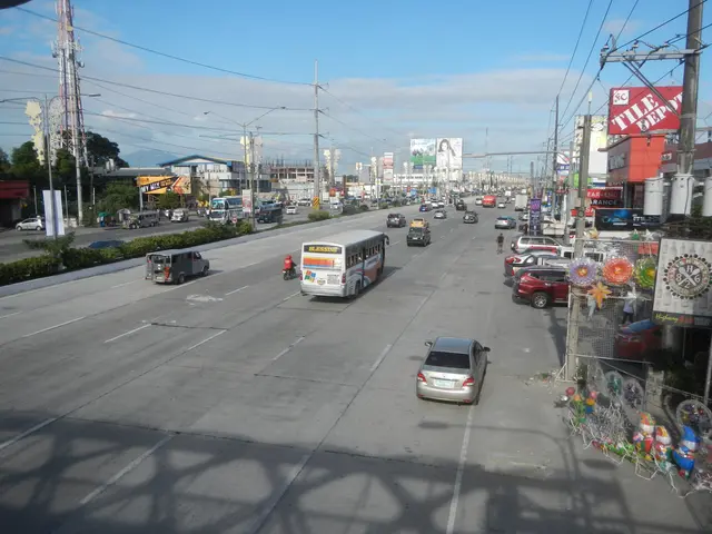 The image shows a city street filled with lots of traffic, including cars, buses, and trucks. There...