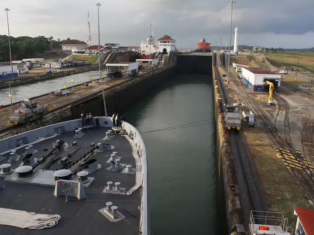 The image shows a ship going through the Panama Canal in Panama City, Panama. On the left side of...