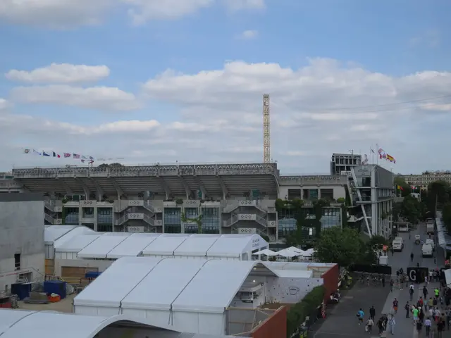 The image shows a view of the Olympic Stadium from the top of a building. We can see a group of...