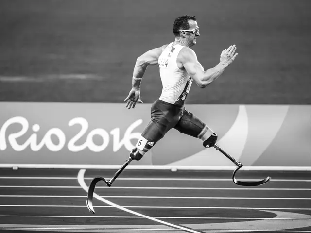 The image shows a man with a prosthetic leg running on a track, with a board in the background...