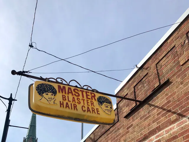 The image shows a building with a sign that reads "Master Blaster Hair Care" on the side of it,...