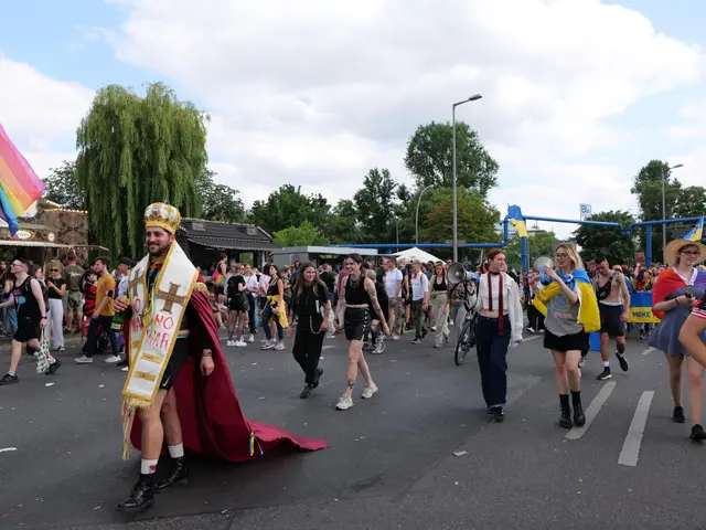 The image shows a group of people walking down a street with a rainbow flag, some of them holding...