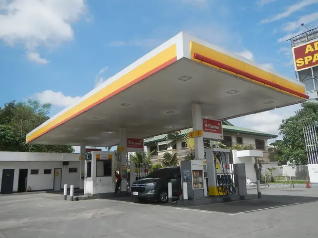 The image shows a gas station with a car parked in front of it, surrounded by buildings, trees, and...