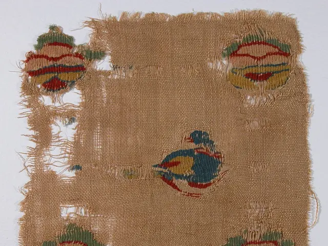 The image shows a piece of jute cloth with a colorful embroidered design on it, set against a white...