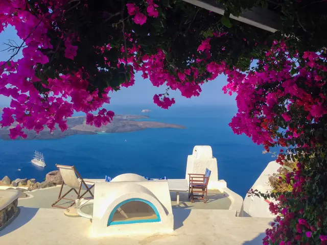 The image shows a stunning view of the ocean from the top of a building in Santorini, Greece. We...
