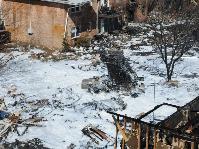 The image shows the aftermath of a fire in a residential neighborhood, with the remains of a house...