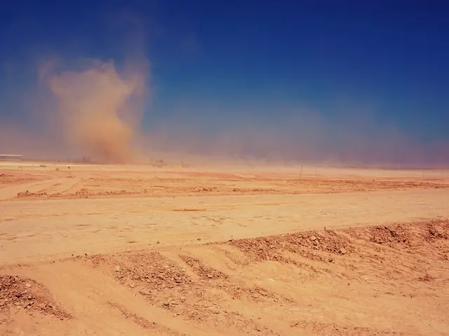 The image shows a dust storm in the Sahara Desert, with sand on the ground and a building in the...